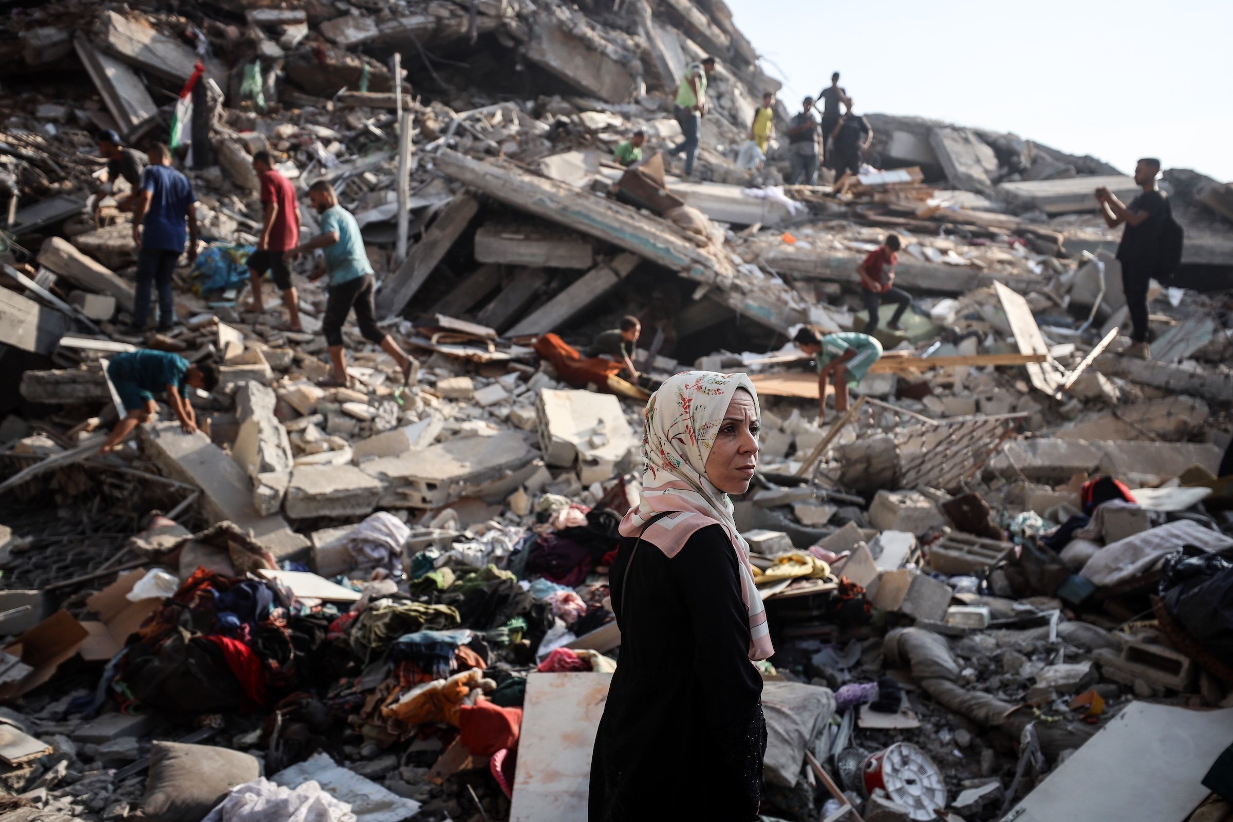 Displaced Palestinians gather in front of the rubble of a building, leveled in an overnight Israeli strike that also damages the surrounding tents used as temporary shelters, in the Rimal neighborhood of Gaza City, on September 15, 2025.