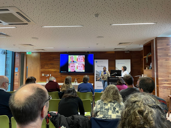 A slide with a meme about AI accountability and two women on stage in a seminar room