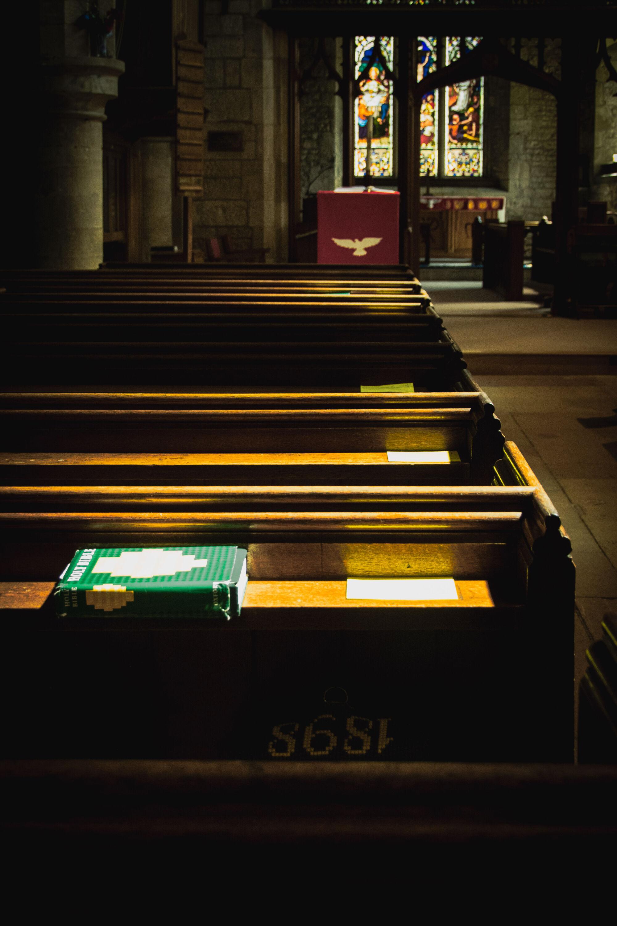 Church interior.  Looking over the pews towards the alter.  Pews caught in the sunlight.